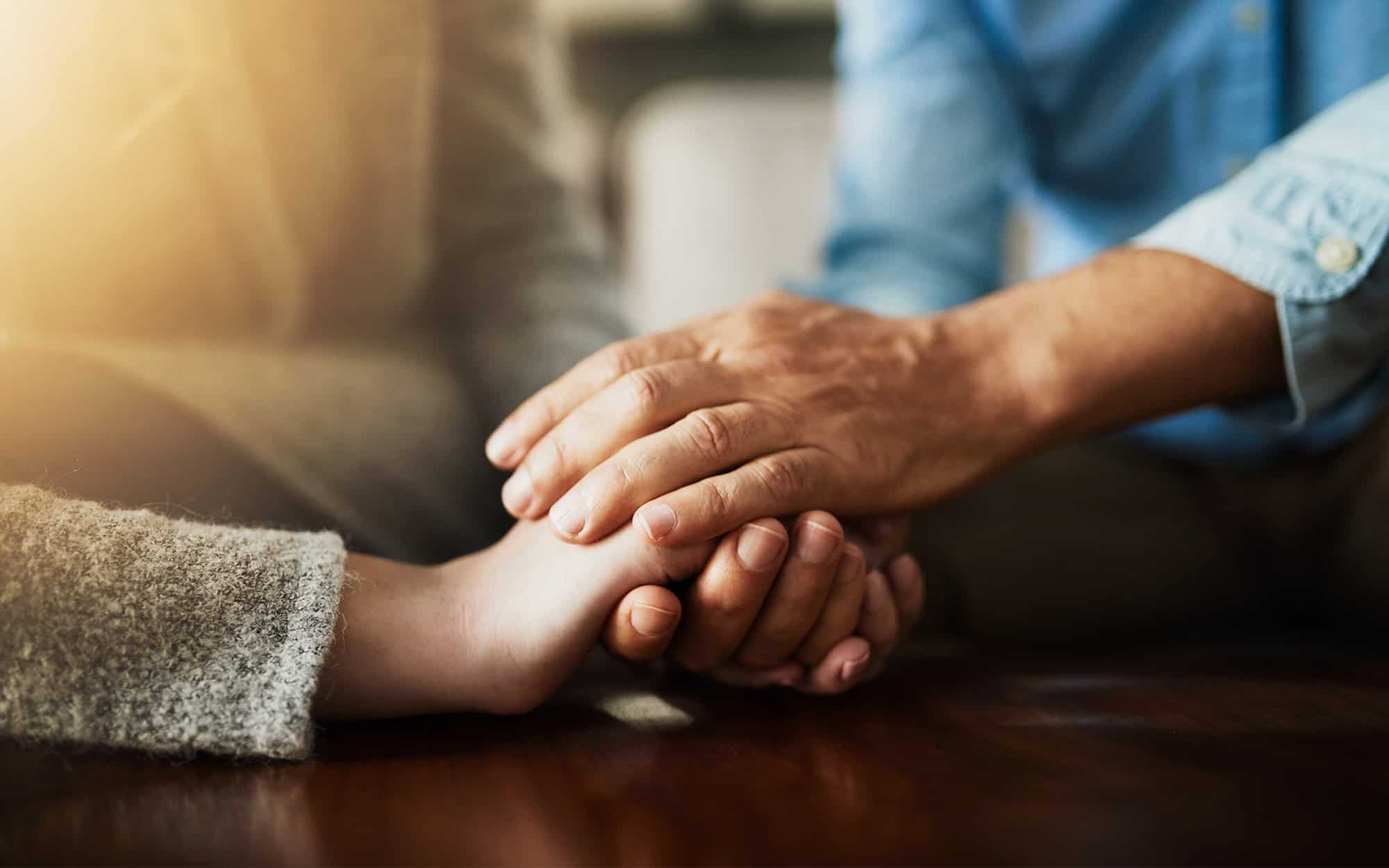 Front view of two elders holding hands